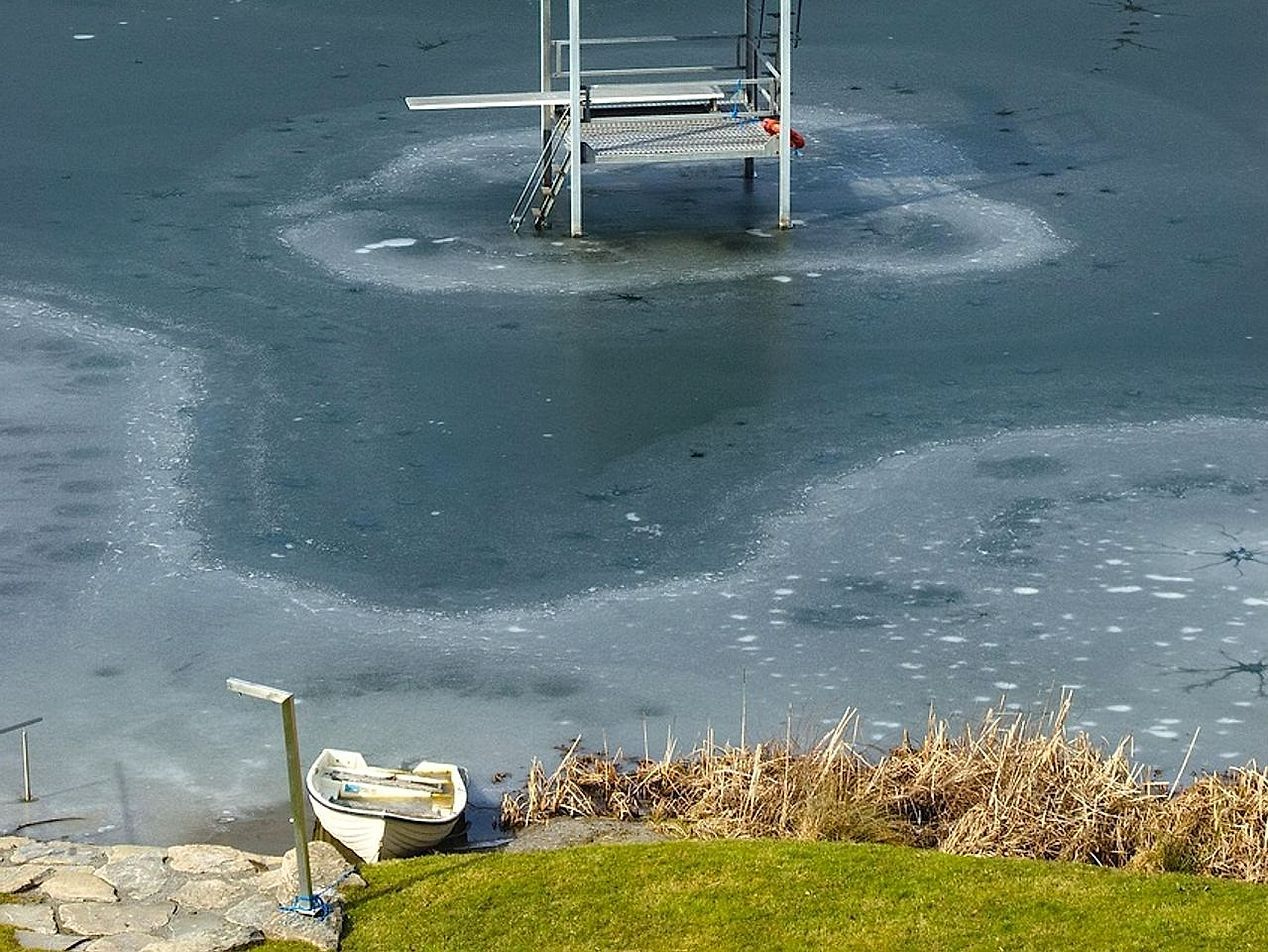 Aguas quietas del lago en las montañas bajo colinas bajas